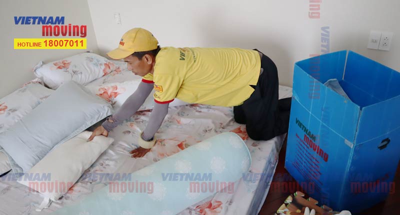 Nhân viên lấy chăn, ga, gối cho vào thùng